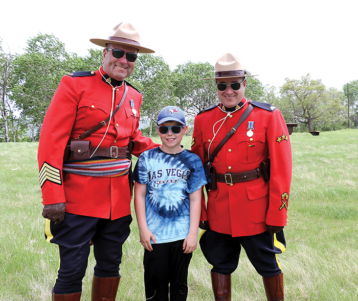 S/Sgt. Matt Lavallee and Corporal Brett Church of Prairie Mountain RCMP with a local student at the celebration of the site. <br />